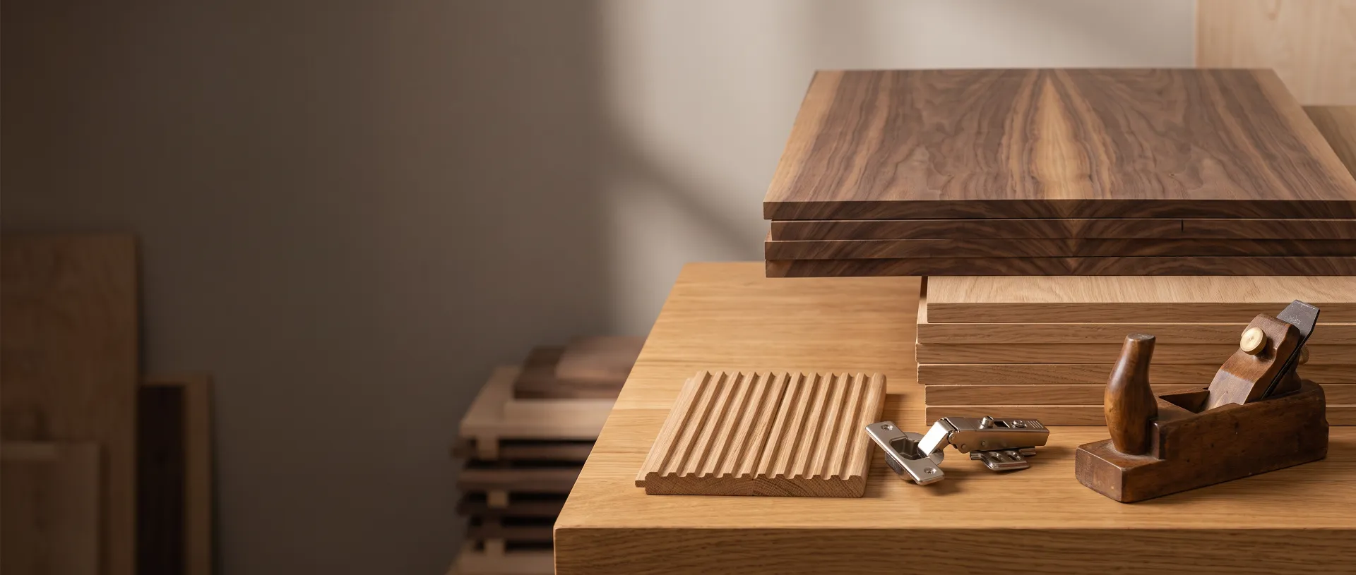 Walnut and oak veneer sheets, a fluted panel sample and a hand plane on a workshop bench