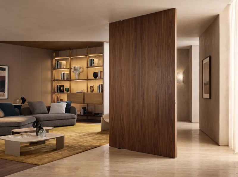 Large walnut pivot door between living room and hallway