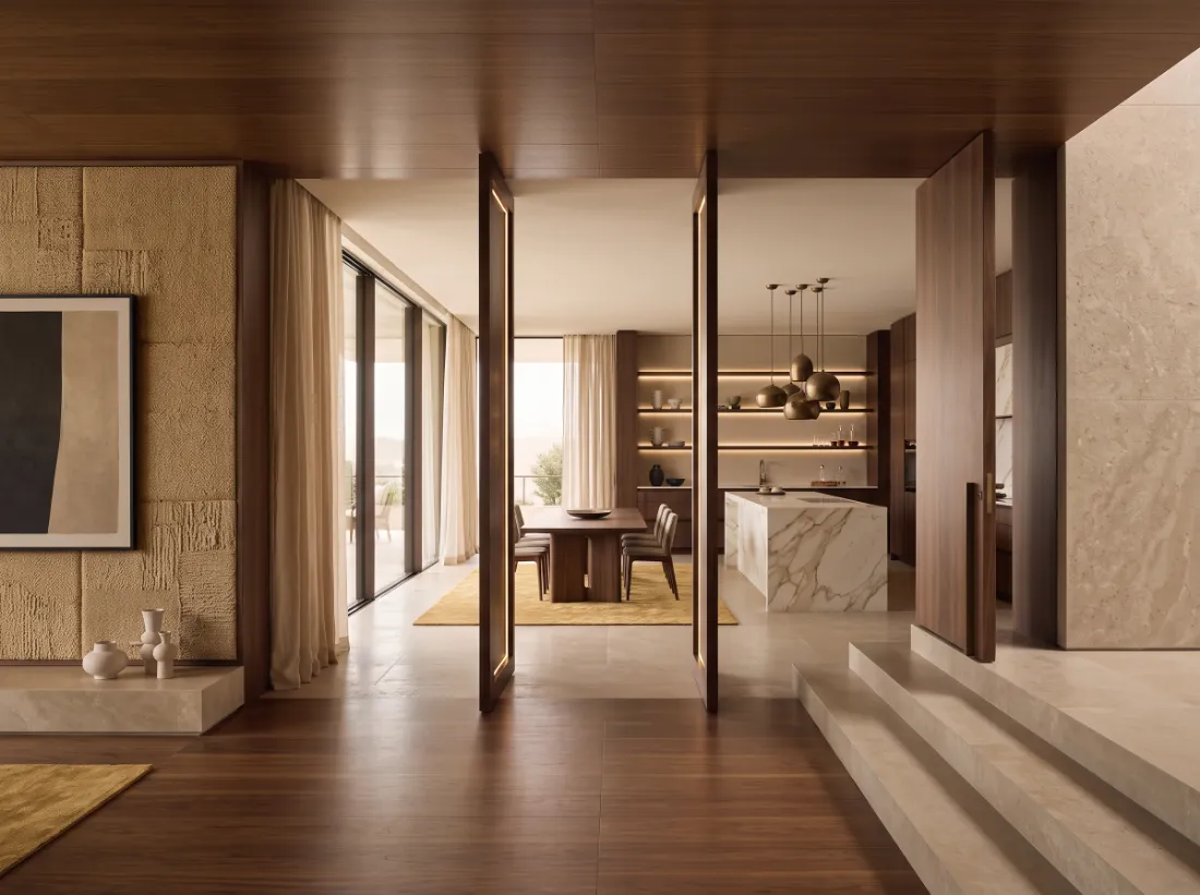 Villa interior with walnut kitchen, stone floor, pendant lights and a walnut pivot door
